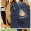 SÉRIE OS MONSTROS CAEM NA NATUREZA – Bolsa Avental Jeans